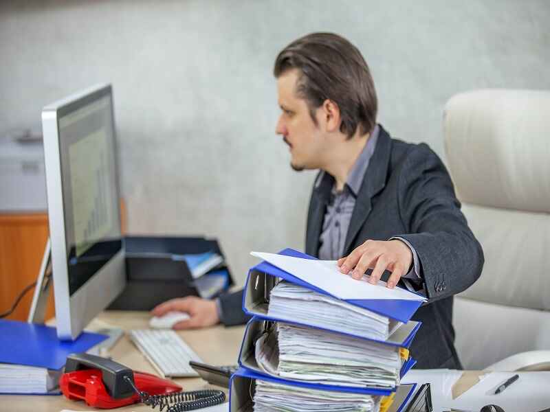 The image depicts a man working in an office setting: 